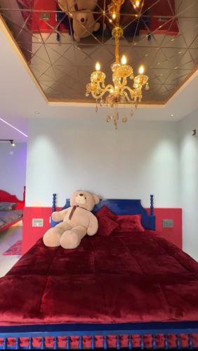 a teddy bear sitting on a bed in a bedroom at Teddy in Malpe