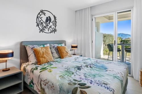 a bedroom with a bed with a view of a balcony at Solana Village in Málaga