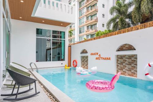 a pool at a hotel with a pink inflatable chair at Downtown Oasis 芭提雅市中心独栋泳池别墅 A 5卧6卫 KTV BBQ 芭提雅海滩步行街500m in Pattaya South