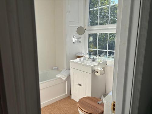 a bathroom with a tub and a sink and a toilet at Applegarth House in Lockerbie