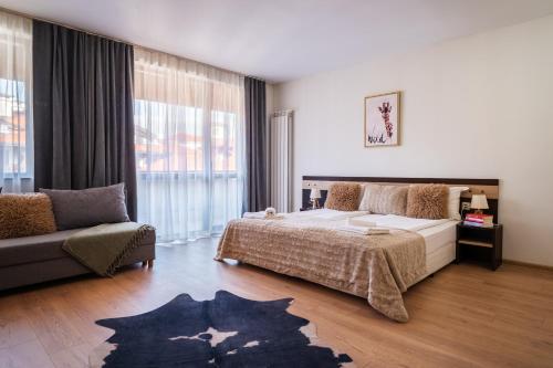 a bedroom with a large bed and a couch at Apart Hotel Dream in Bansko