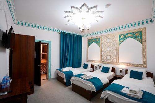 a hotel room with two beds and a chandelier at RAY Boutique Hotel withTerrace in Bukhara