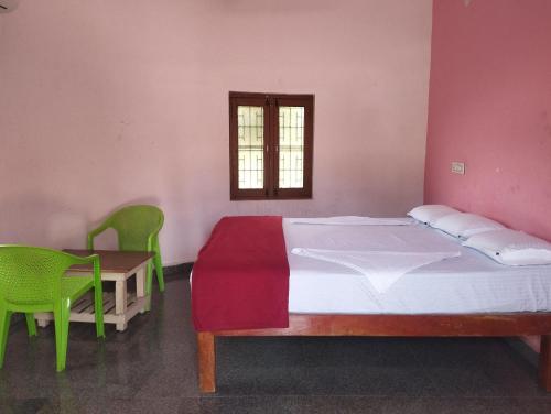 a bedroom with a bed and a table and chairs at Hampi Blue Moon Resort in Munirābād
