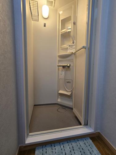 a bathroom with an empty refrigerator in a room at Kobe Youth Hostel in Kobe
