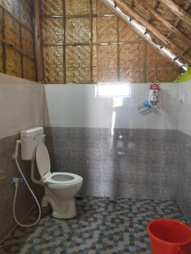 a bathroom with a toilet in a room at Hampi Blue Moon Resort in Munirābād