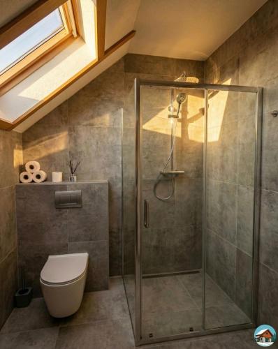 a bathroom with a shower and a toilet at Chata Hrbánik Tále in Bystrá
