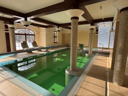 a swimming pool with pillars in a building with a pool at Pałac w Rymaniu in Rymań