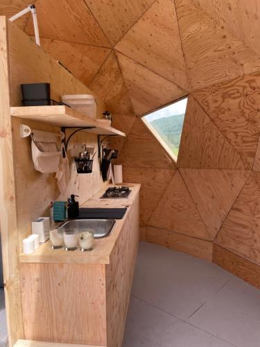 a kitchen in a wooden house with a window at Prêt-à-camper, dôme in La Tuque