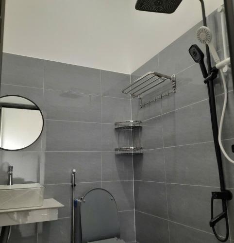 a bathroom with a shower and a toilet and a mirror at NT Bell Homestay in Ninh Hải