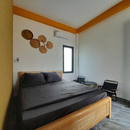 a bedroom with a large bed with two chairs at NT Bell Homestay in Ninh Hải