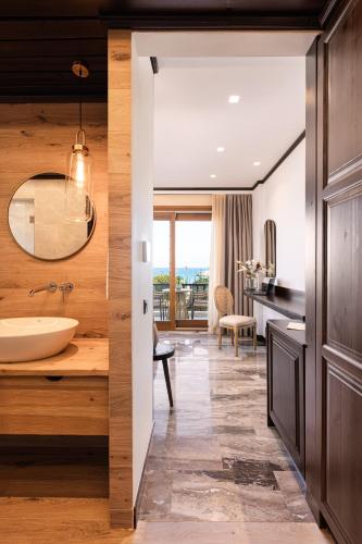 ein Badezimmer mit Waschbecken und Waschtisch mit Spiegel in der Unterkunft Sunrise Hotel in Ireo