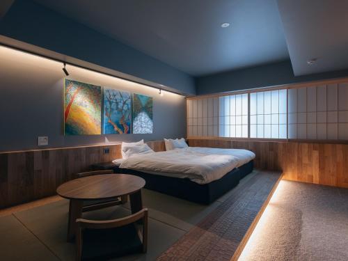 a bedroom with a bed and a table in it at Experience Ise Miyamachi Hotel in Ise