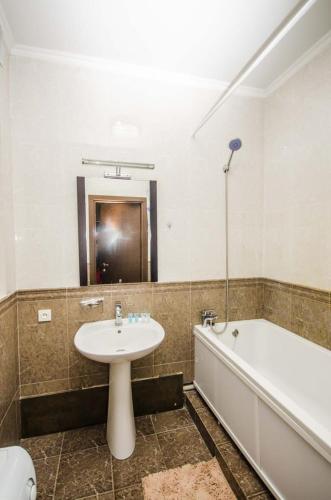 a bathroom with a sink and a bath tub at Abylai Khan 113 Central in Almaty
