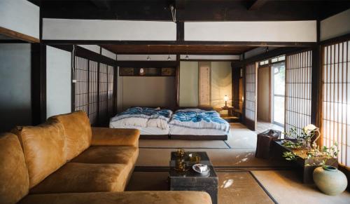 a living room with a bed and a couch at 里の宿 門後藤 in Taketa