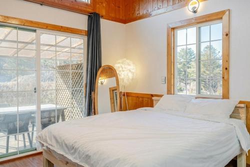 a bedroom with a bed and a large window at Yangpyeong Narinsoom Private Villa in Yangpyeong