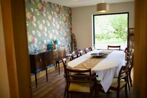 a dining room with a table and chairs and a window at Tate's Meadow in Banbridge