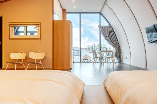 a bedroom with two beds and a table and chairs at Ganghwa Aiem Glamping in Incheon