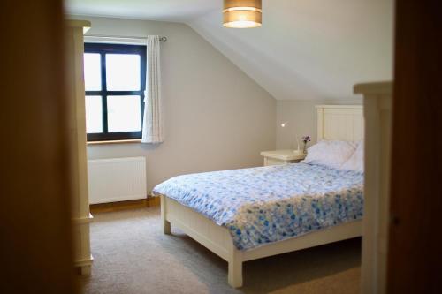 a bedroom with a bed and a window at Tate's Meadow in Banbridge