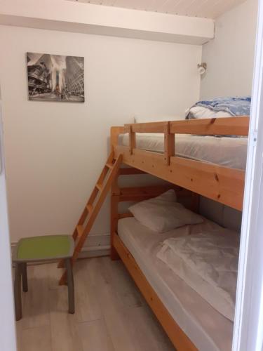 a bedroom with two bunk beds and a chair at Cocon Marin 2 Etoiles - Face Océan et Balcon in Fort-Mahon-Plage