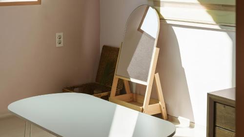 a mirror in a room with a table and a chair at Boryeong (Daecheon) Jeil Pension in Boryeong