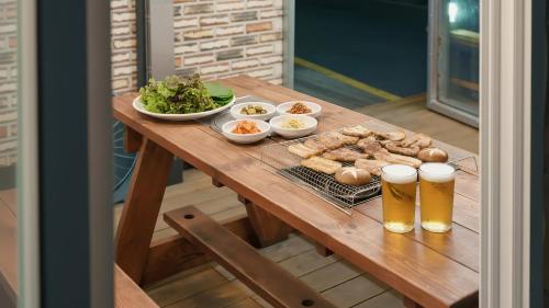 a table with a tray of food and two glasses of beer at Boryeong (Daecheon) Jeil Pension in Boryeong