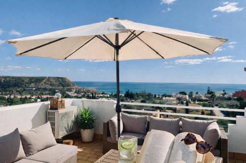 a white umbrella sitting on top of a balcony at Dreamy Sea View Apartment with Access to Private Pool & Stunning Rooftop in Luz