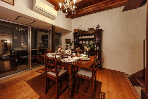 a dining room with a wooden table and chairs at Antiques Nagoya Station East -アンティークス名古屋駅東- in Nagoya