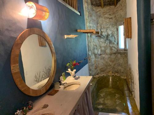 a bathroom with a sink and a mirror and a tub at Bangalô 12 in Porto Seguro