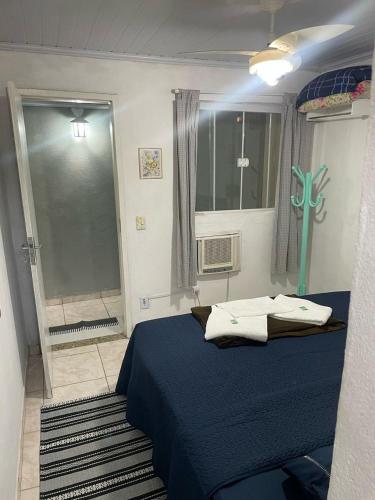a bedroom with a blue bed and a window at Pousada Chuá Chuá in Conservatória