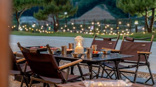 a table with chairs and a lantern on top of it at Mungyeong The Most Glamping in Mungyeong