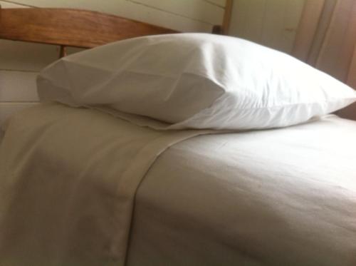a white pillow sitting on top of a bed at Hostal Patrimonial Angelmó in Puerto Montt
