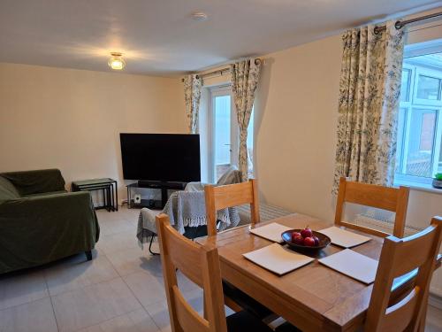 a dining room with a table and a television at Family-run 5 Star Home - Consistent Superhosts in Long Lawford