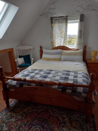 a bedroom with a large bed with a checkered blanket at Connemara sea side house, dog paradise! in Leagaun