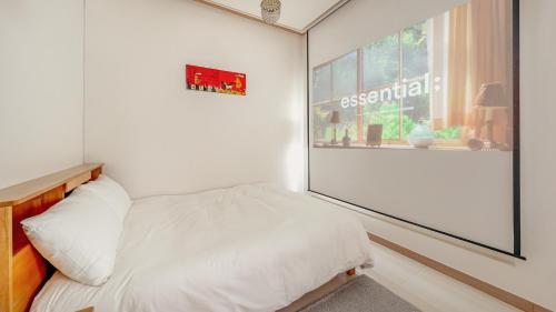 a bedroom with a bed and a large window at Gapyeong Ribbon Spa Pool Villa in Gapyeong