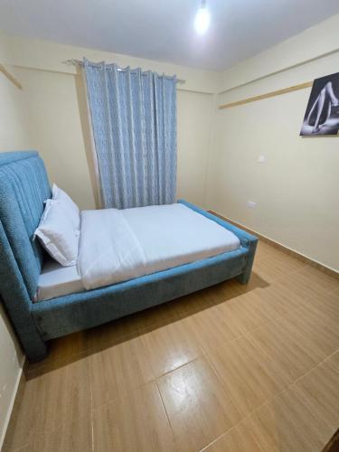 a bedroom with a bed and a blue couch at Tulivu 2 stays in Nyahururu