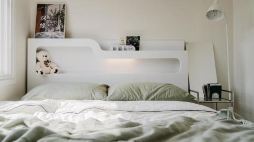 a white bed with a white headboard in a bedroom at Yeongheungdo Stay Noc Pool Villa in Incheon