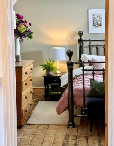 a bedroom with a bed and a desk with a lamp at 6 Luxury home near family park Pet friendly in Merthyr Tydfil