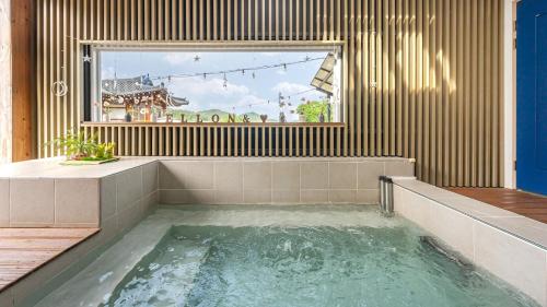 a bath tub in a room with a window at Yeosu Elon Pension in Yeosu