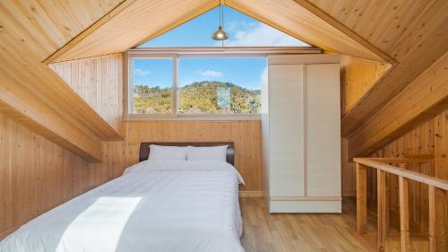 a bed in a room with a window at Yeongheungdo Rainbow Ocean View Pension in Incheon