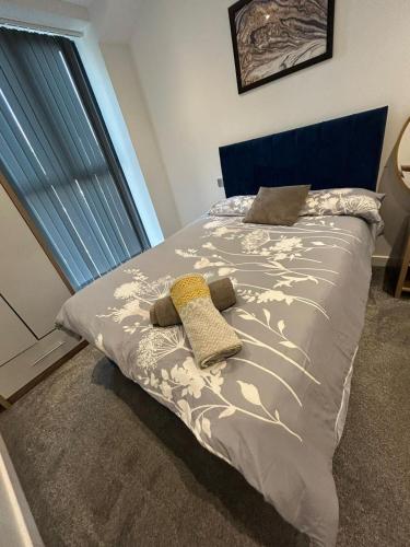 a bed with a blue headboard and two pillows on it at The Courthouse Stylish Serviced Living in Ramsgate
