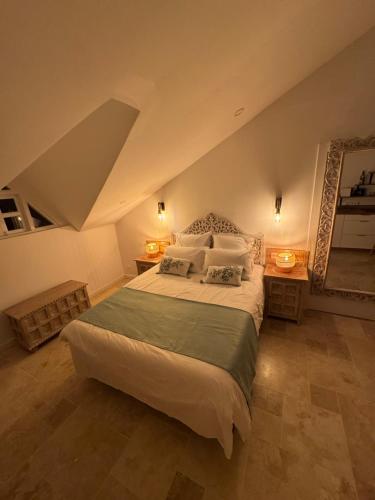 a bedroom with a large bed and two night stands at Le Cocoon SPA du MAIDO in Le Guillaume