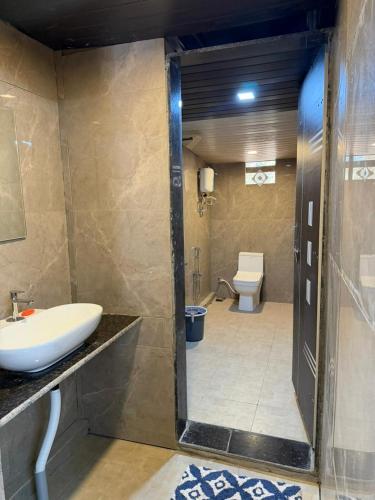 a bathroom with a sink and a toilet at Adventure Inn Dandeli in Kurandi