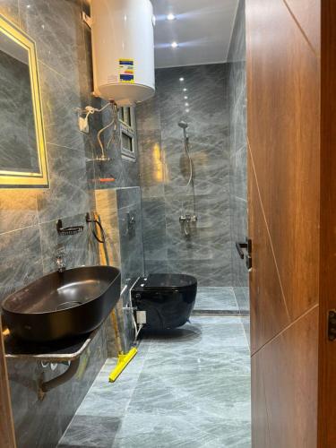 a bathroom with a black sink and a tub at Cloud pyramids view inn in ‘Ezbet `Abd el-Ḥamîd