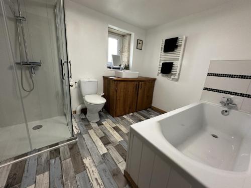 a bathroom with a tub and a toilet and a shower at Esprit Charentais - The Byre in Londigny