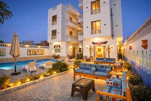 a villa with a swimming pool and a resort at Astralis Hotel - Hot Air Balloon View in Al Aqālitah