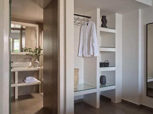 a bathroom with white shelves and a sink and a mirror at Ionian Hill Hotel in Argassi