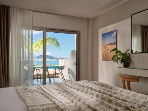 a bedroom with a bed and a view of the ocean at Ionian Hill Hotel in Argassi