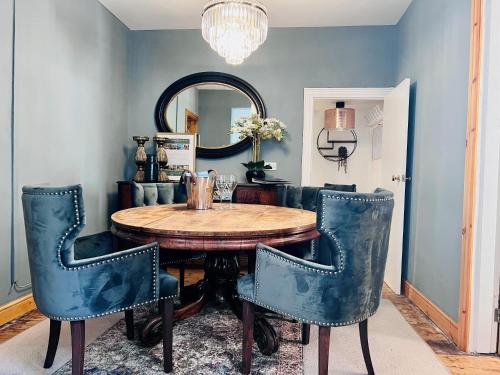 a dining room with a wooden table and blue chairs at 6 Luxury home near family park Pet friendly in Merthyr Tydfil