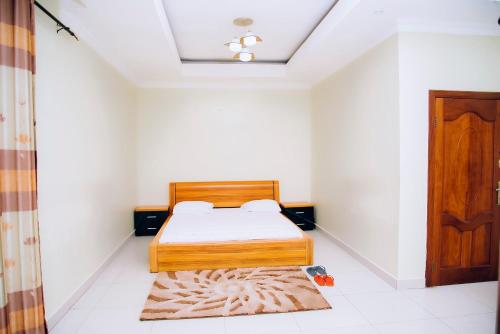 a bedroom with a bed and a door and a rug at Stella nova motel in Kigali
