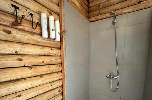 a shower in a bathroom with a wooden wall at Terranova Glamping in Luján